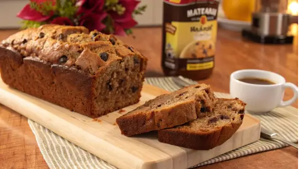 How long can I store banana bread? Freshly baked banana bread on a wooden board, ready to be stored for freshness.